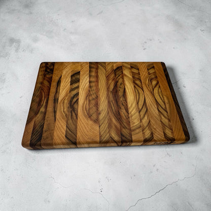 Fab Slabs Online Store premium hardwood chopping board with unique timber grain patterns on a grey stone surface.