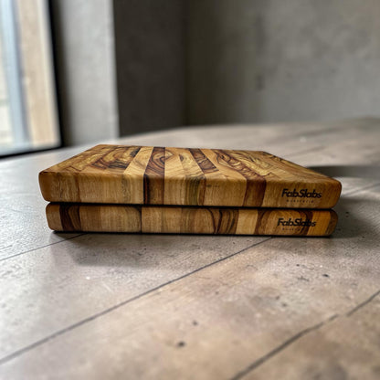 Two Fab Slabs Online Store premium hardwood chopping boards stacked, showing natural timber grain and brand logo.